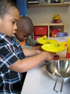 Two kids playing with marbles